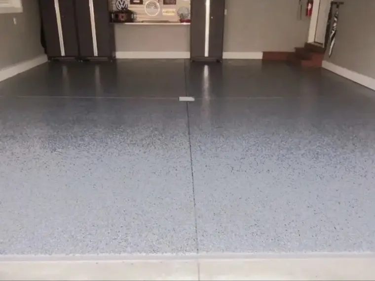 Gray flake floor running between painted columns in a garage