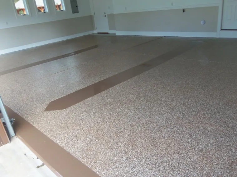 Gray decorative flake garage floor with a darker inlaid stripe