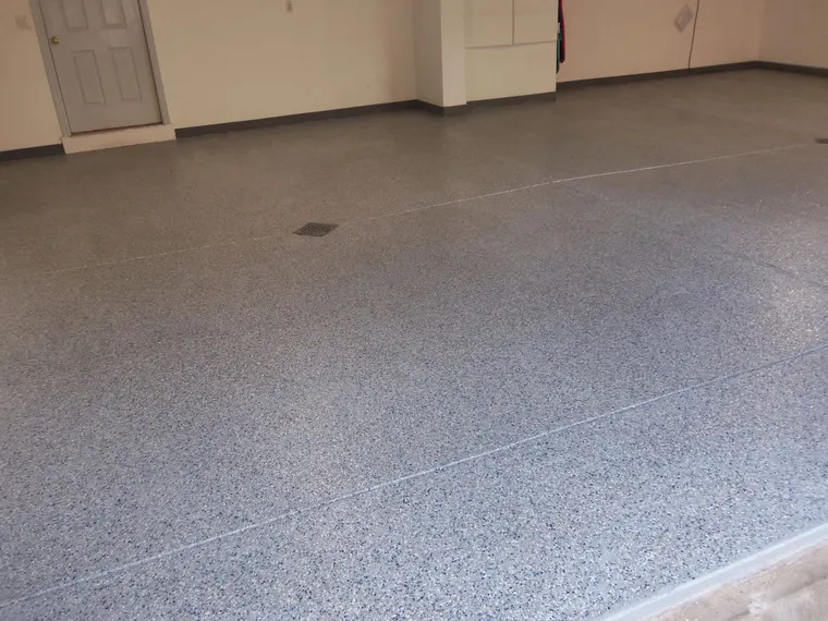 Gray speckled flake floor finished wall to wall in a garage