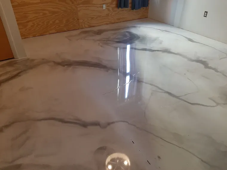 Gray and white metallic epoxy floor with a marbled swirl and a mirror finish